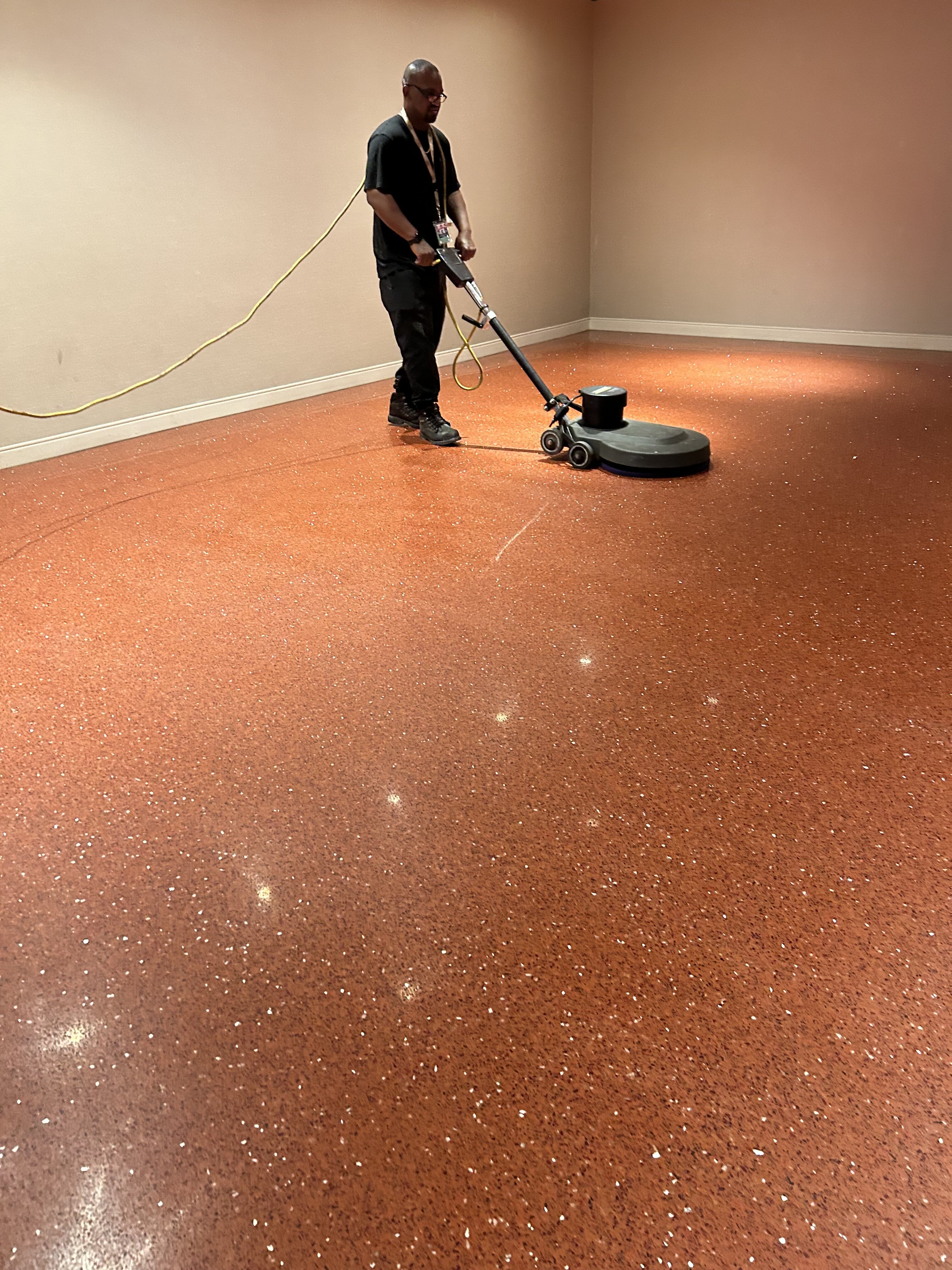 Technician honing a terrazzo floor with a polishing machine